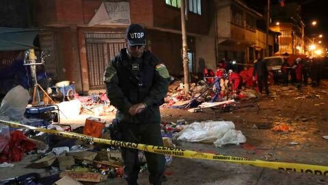 Una unidad de bomberos y miembros de la polic&iacute;a inspeccionan el lugar donde se produjo una explosi&oacute;n