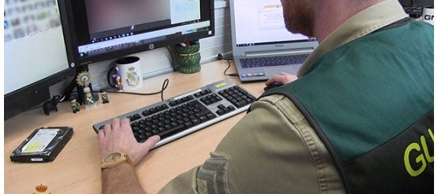 Un agente de la Guardia Civil analizan las fotografías que tenía el depredador sexual detenido Un agente de la Guardia Civil analizan las fotografías que tenía el depredador sexual detenido