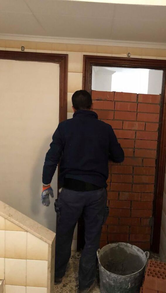 Operario tapia el acceso a una vivienda vacía 