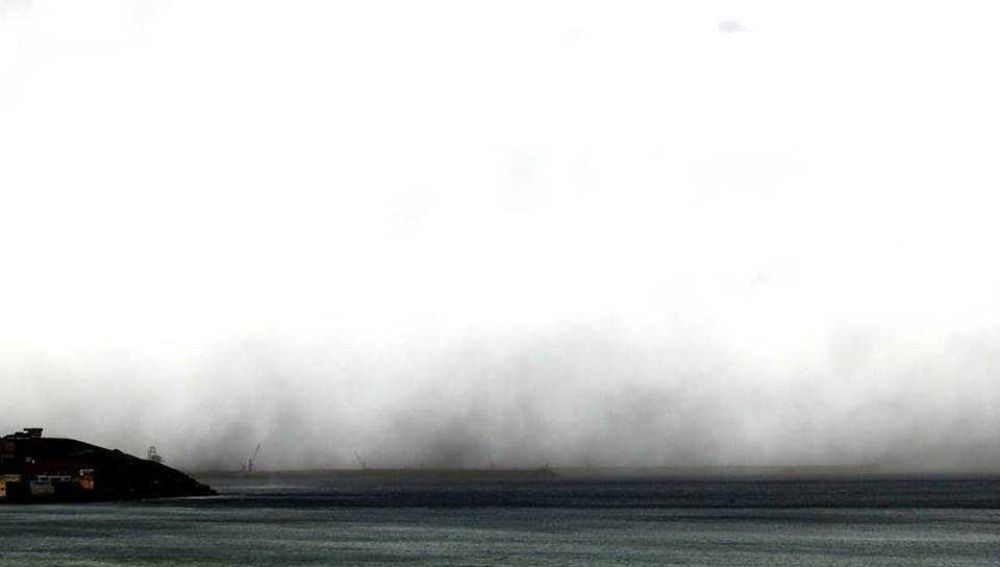 El viento levanta una nube de carbón en El Musel (Gijón)