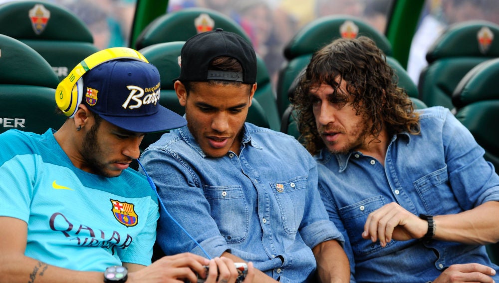 Neymar enseña su móvil a Jonathan dos Santos y a Puyol