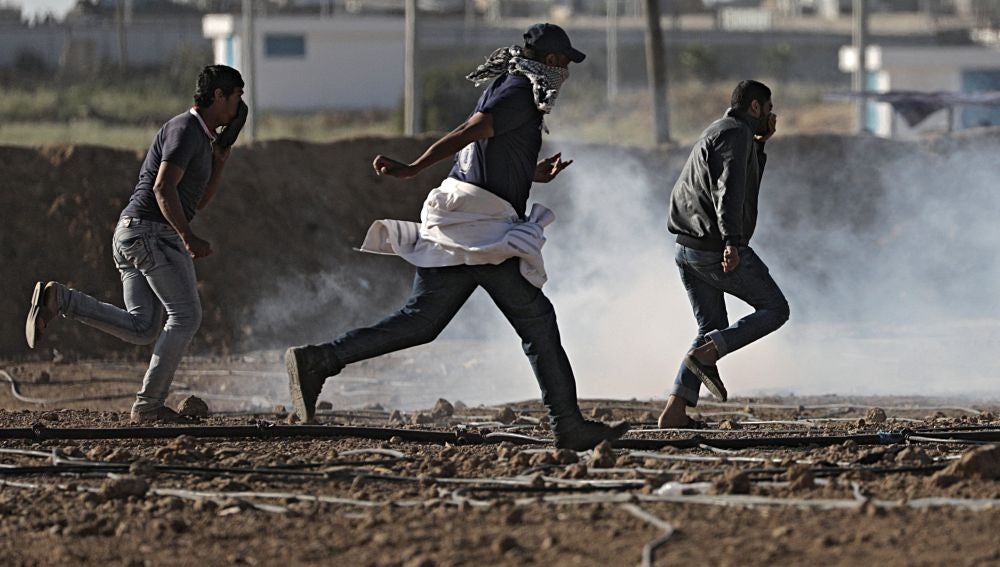 Varios palestinos corriendo durante las protestas en Gaza