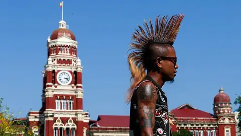 Reunión Punk de cara al Festival del Agua en Rangún (12-04-2018) Un hombre que luce una cresta pasa junto al edificio del Tribunal Supremo birmano mientras participa en una reunión punk, de cara al festival Thingyan del agua en Rangún (Birmania). La reunión de punks en Rangún se celebra de forma anual antes del festival, en el que un gran número de personas se congregan para lanzarse polvo de colores y luego salpicarse con agua, como símbolo de limpieza de los pecados. Esta celebración marca el año nuevo de varios países como Birmania, Tailandia y Camboya.