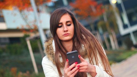 Una adolescente mira el m&oacute;vil
