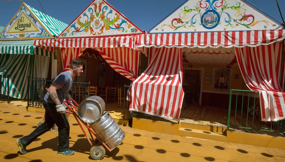 Un joven trabaja en los preparativos de la celebración de la Feria de Abril