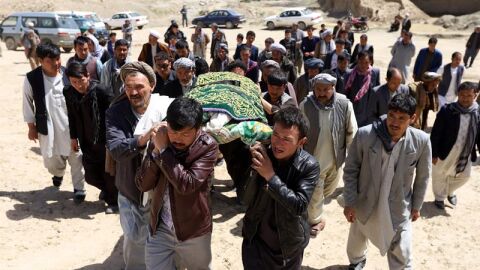 Varias personas trasladan un cad&aacute;ver tras el atentado en Kabul