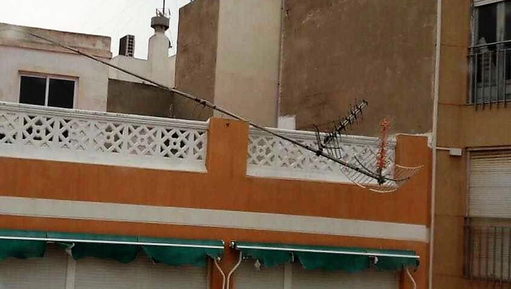 Antena desprendida por el viento en la terraza de un edificio de Elche