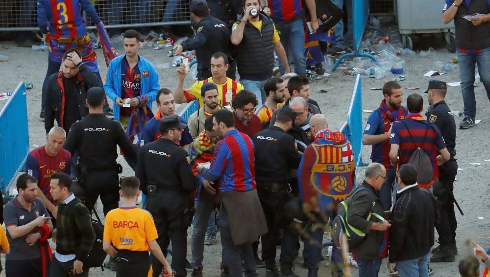Agentes de la Policía Nacional junto a seguidores del Barcelona en los exteriores del Wanda Metropolitano