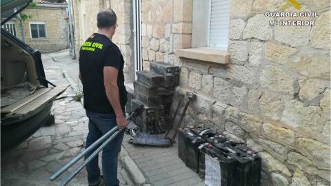 Un agente de la Guardia Civil junto a efectos recuperados en la operaci&oacute;n