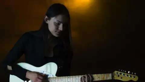 Una chica tocando la guitarra eléctrica en un pub Una chica tocando la guitarra eléctrica en un pub