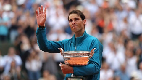 Rafa Nadal saluda al p&uacute;blico con el trofeo de Roland Garros