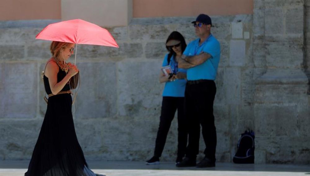 Una mujer se protege del calor con un paraguas