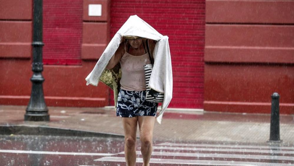 Una mujer camina bajo la lluvia durante una tormenta