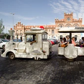 Grupo de turistas recorre la ciudad en un tren turístico Grupo de turistas recorre la ciudad en un tren turístico
