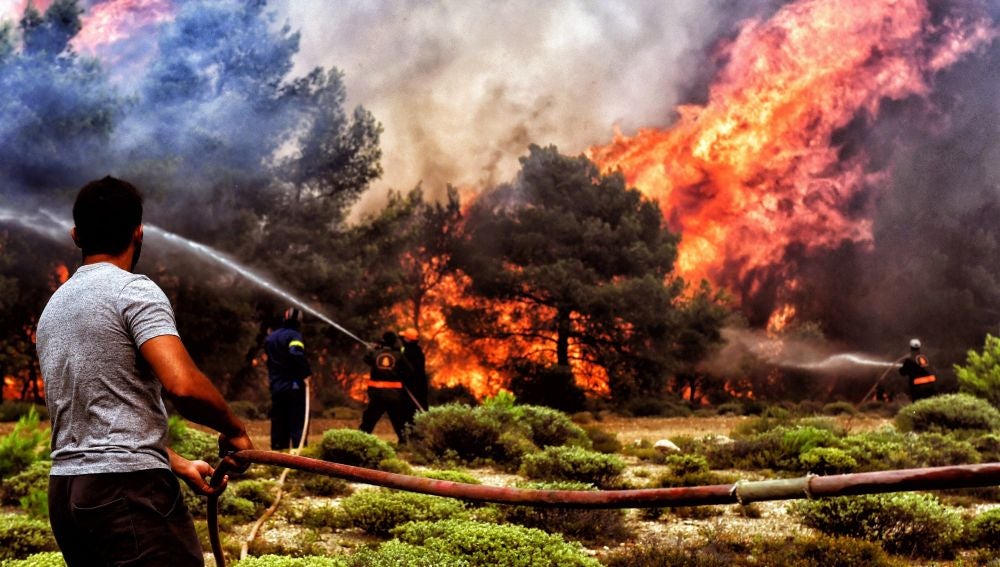Varios bomberos y voluntarios luchan contra las llamas en un incendio en Verori, cerca de la ciudad de Loutraki (Grecia)