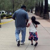 Un hombre camina junto a su hija tras salir de una cita en la Oficina de Control de Inmigración y Aduanas 