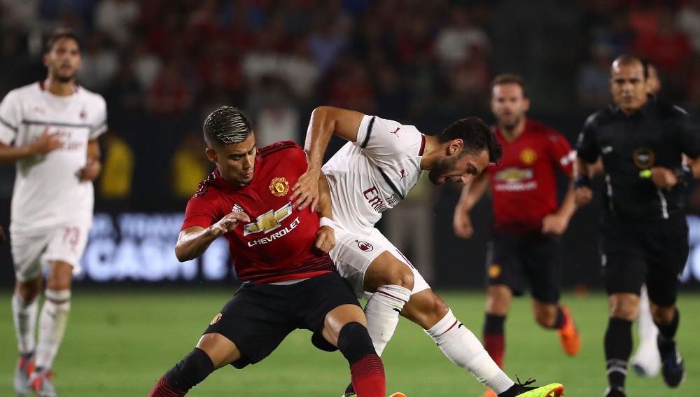Hakan Calhanoglu y Andreas Pereira pelean por un balón