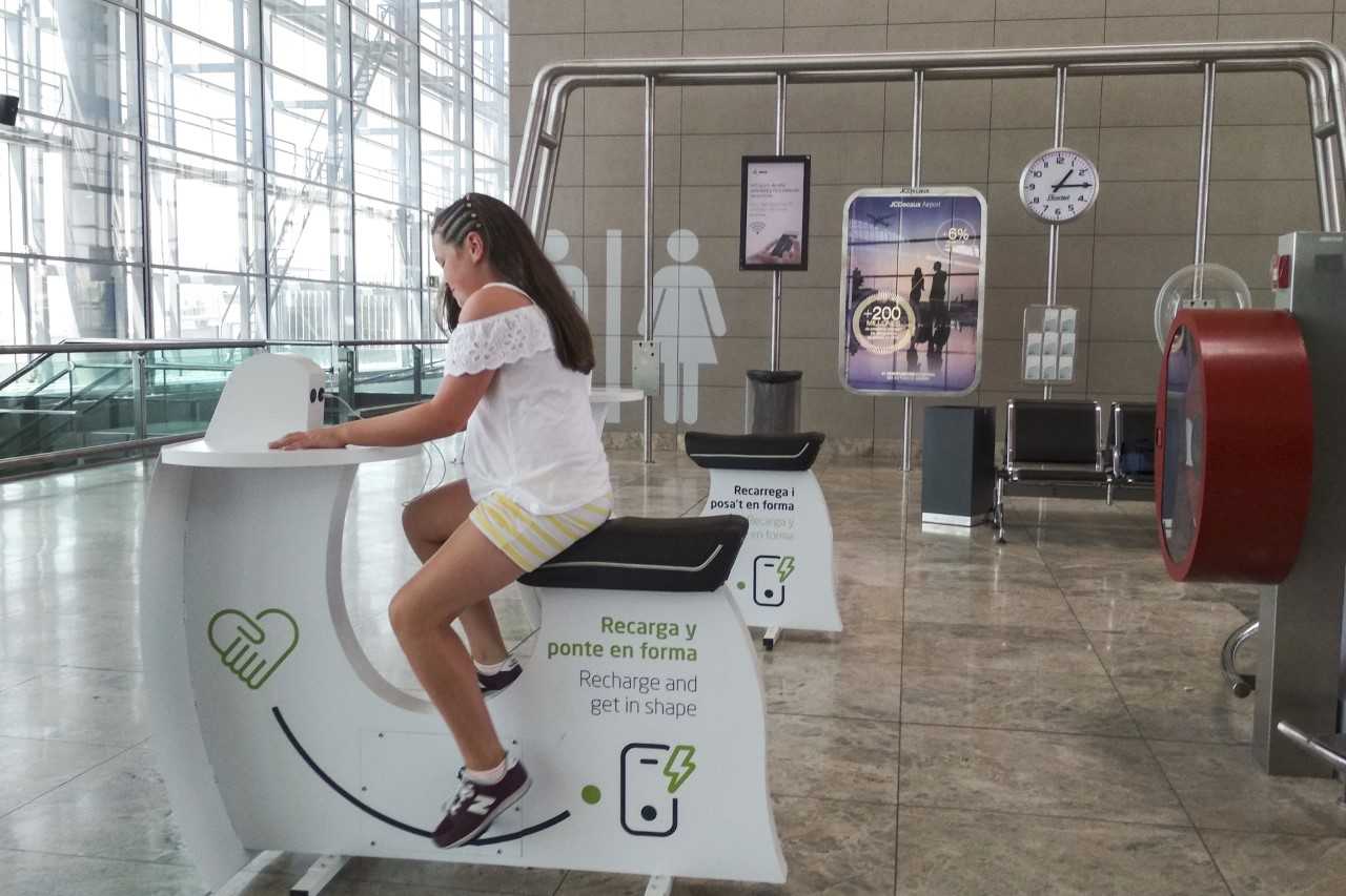 El Aeropuerto de Alicante-Elche instala cuatro bicicletas estáticas para la carga de teléfonos móviles El Aeropuerto de Alicante-Elche instala cuatro bicicletas estáticas para la carga de teléfonos móviles