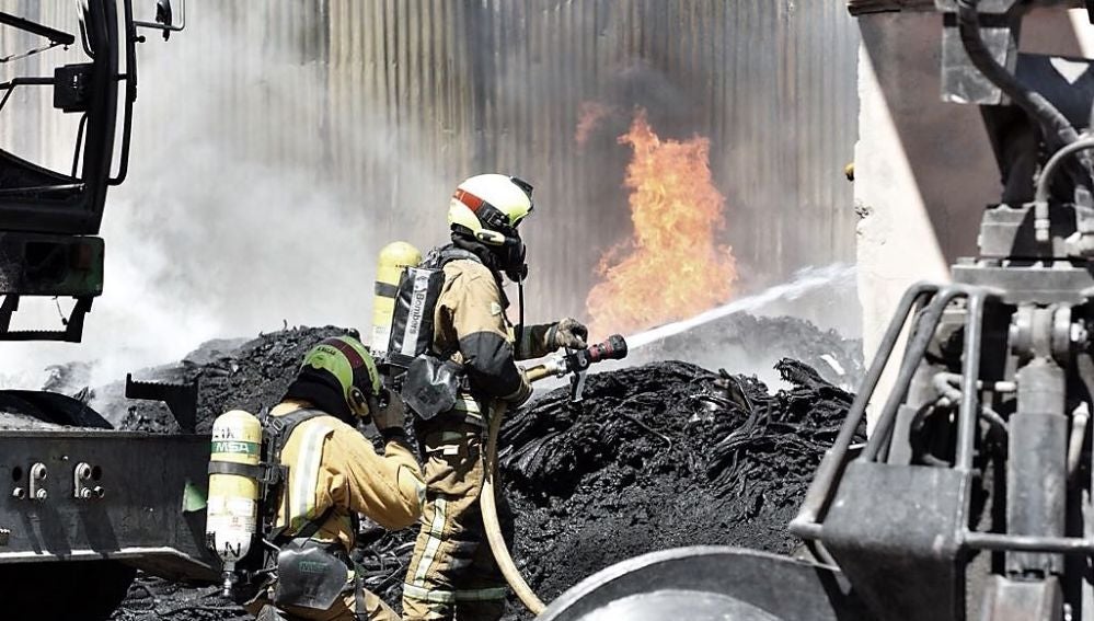Bomberos en las labores de extinción del incendio en el polígono industrial de Carrús de Elche
