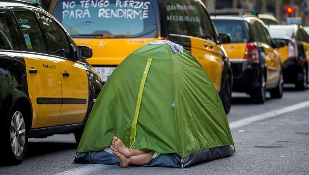 Un taxista acampa junto a la hilera de taxis en el centro de Barcelona