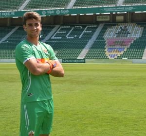 Unai Simón posando ante el escudo del club con la equipación franjiverde Unai Simón posando ante el escudo del club con la equipación franjiverde
