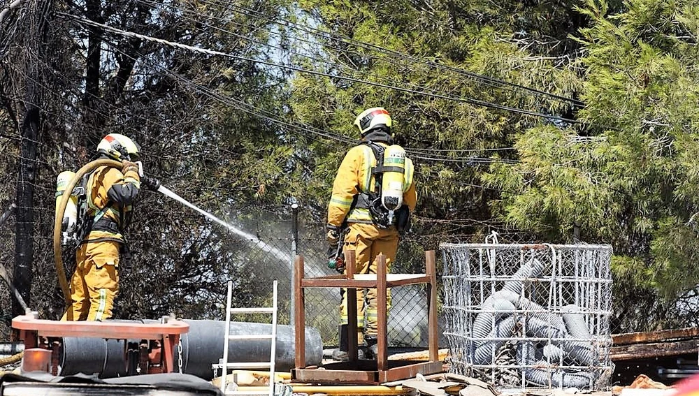Dos bomberos en las labores de extinción del incendio en el polítgono industrial de Carrús