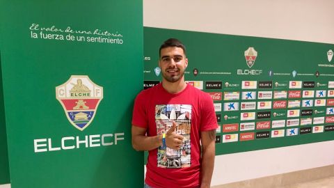 Alex&aacute;nder Gonz&aacute;lez posa junto al escudo del Elche CF en su llegada al estadio.