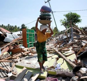 Una mujer carga con sus pertenencias entre los escombros en Lombok (Indonesia) tras el terremoto Una mujer carga con sus pertenencias entre los escombros en Lombok (Indonesia) tras el terremoto