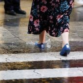 Una mujer cruza por un paso de peatones bajo una fuerte tormenta (Archivo)