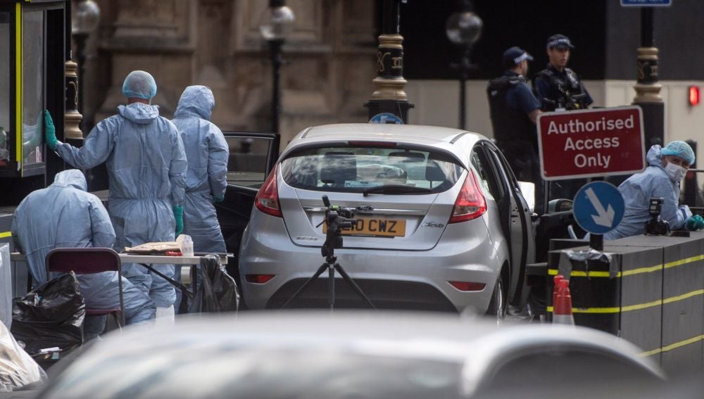 Oficiales forenses examinan el coche que chocó contra las barreras del Parlamento británico 