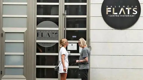 Una pareja de turistas se dispone a entrar en edificio de apartamentos Una pareja de turistas se dispone a entrar en edificio de apartamentos