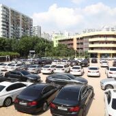 Vista de decenas de vehículos BMW permanecen aparcados en el patio de un colegio en Seúl
