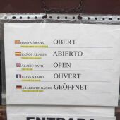 Cartel en la puerta de los Baños Árabes con la bandera catalana