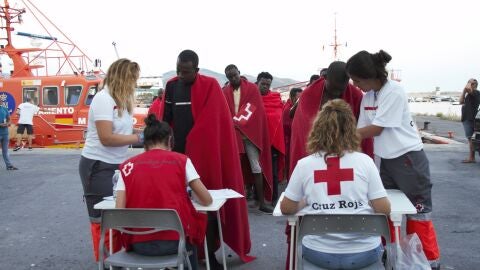 Miembros de la Cruz Roja atienden a decenas de migrantes rescatados por Salvamento Mar&iacute;timo de una patera en la cercan&iacute;as de la Isla de Albor&aacute;n