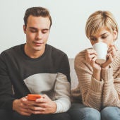 Mujer mirando pantalla de móvil de la pareja