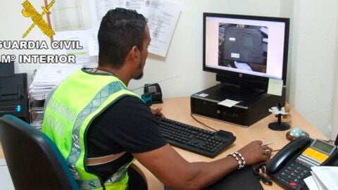 Un agente de la Guardia Civil incautando material pornogr&aacute;fico infantil