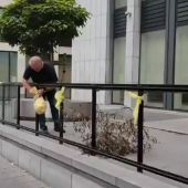 Un operario retira varios lazos amarillos colocados a la entrada del Tribunal belga antes de la vista sobre Llarena