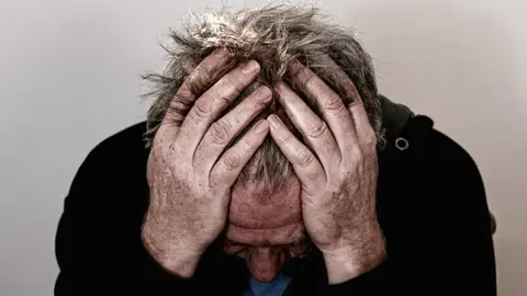 Imagen de archivo de un hombre sufriendo dolor de cabeza Imagen de archivo de un hombre sufriendo dolor de cabeza