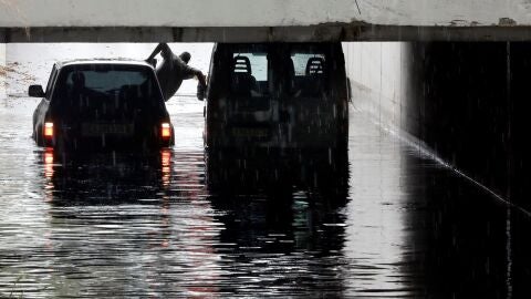 Una persona intenta sale de una furgoneta atrapada en un tunel de Alfafar debido a las intensa lluvias