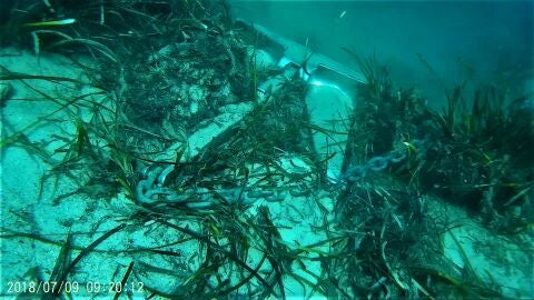 Embarcaci&oacute;n anclada sobre una pradera de posidonia en aguas de Portocolom (Mallorca)