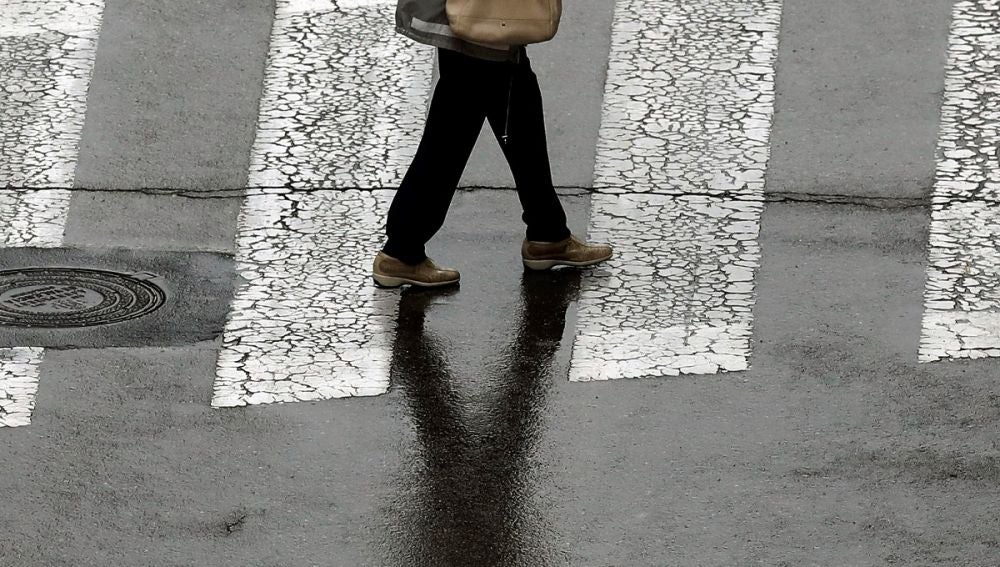 Una persona camina bajo la lluvia