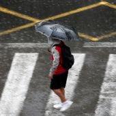 Una persona se protege de la lluvia con un paraguas.