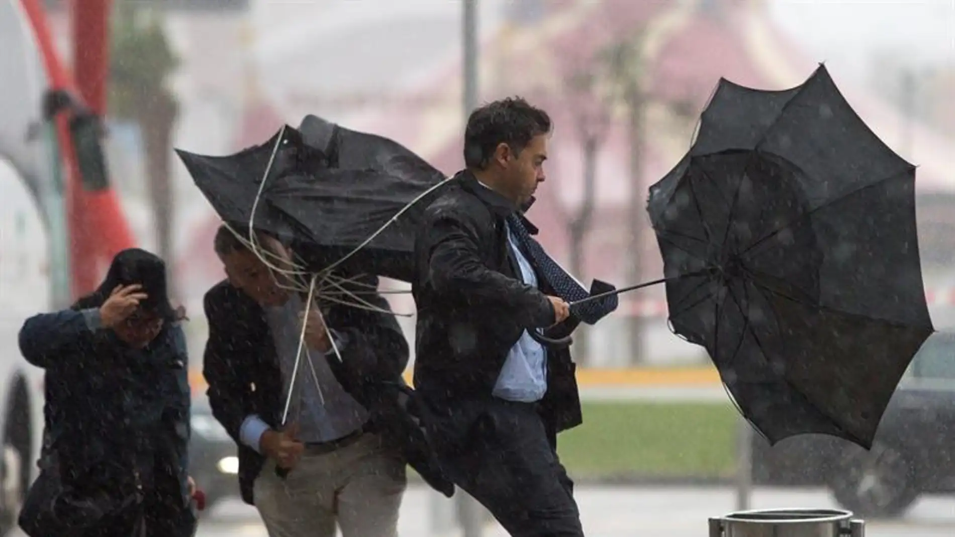 Imagen de archivo: Varias personas sujetan sus paraguas por el fuerte viento.