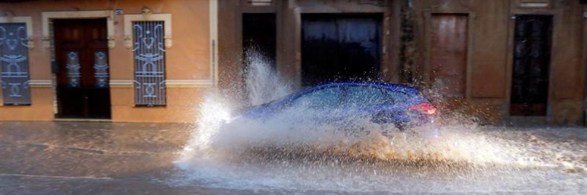 Un vehículo circula por una calle anegada de Valencia Un vehículo circula por una calle anegada de Valencia