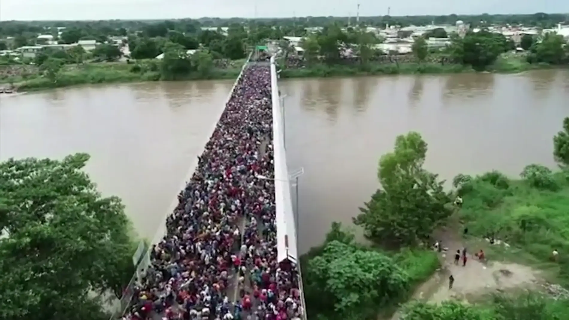 Miles de hondureños fuerzan la valla fronteriza de Guatemala y entran en México a pesar de las amenazas de Trump de no dejarles entrar en EEUU