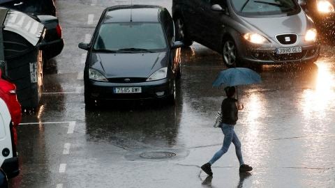 Imagen de una persona que se protege con un paraguas de la lluvia