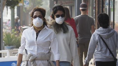 Personas caminando con mascarillas en Oakland, California