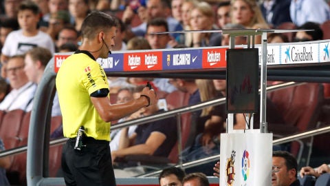 El árbitro Gil Manzano consulta el VAR durante el Clásico