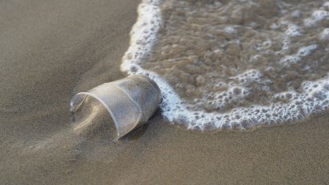 Vaso de pl&aacute;stico en la playa