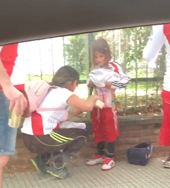 Una mujer pega bengalas en el cuerpo a una menor antes de entrar al Monumental para la final de la Copa Libertadores Una mujer pega bengalas en el cuerpo a una menor antes de entrar al Monumental para la final de la Copa Libertadores